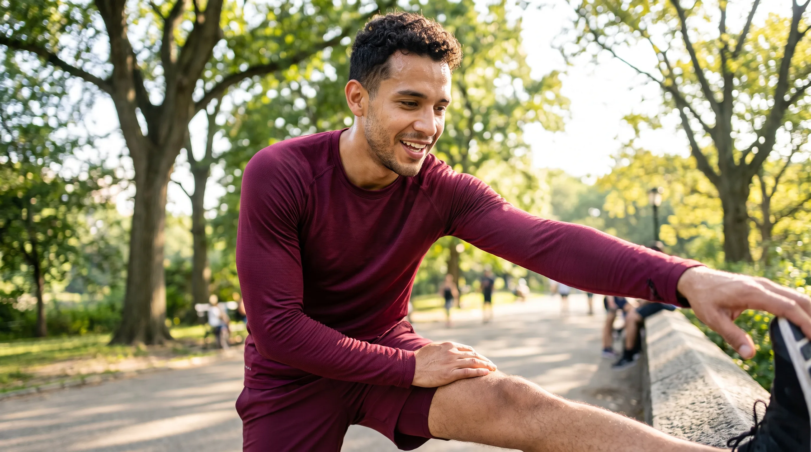 A lean, athletic man in their 20s stretching after a run