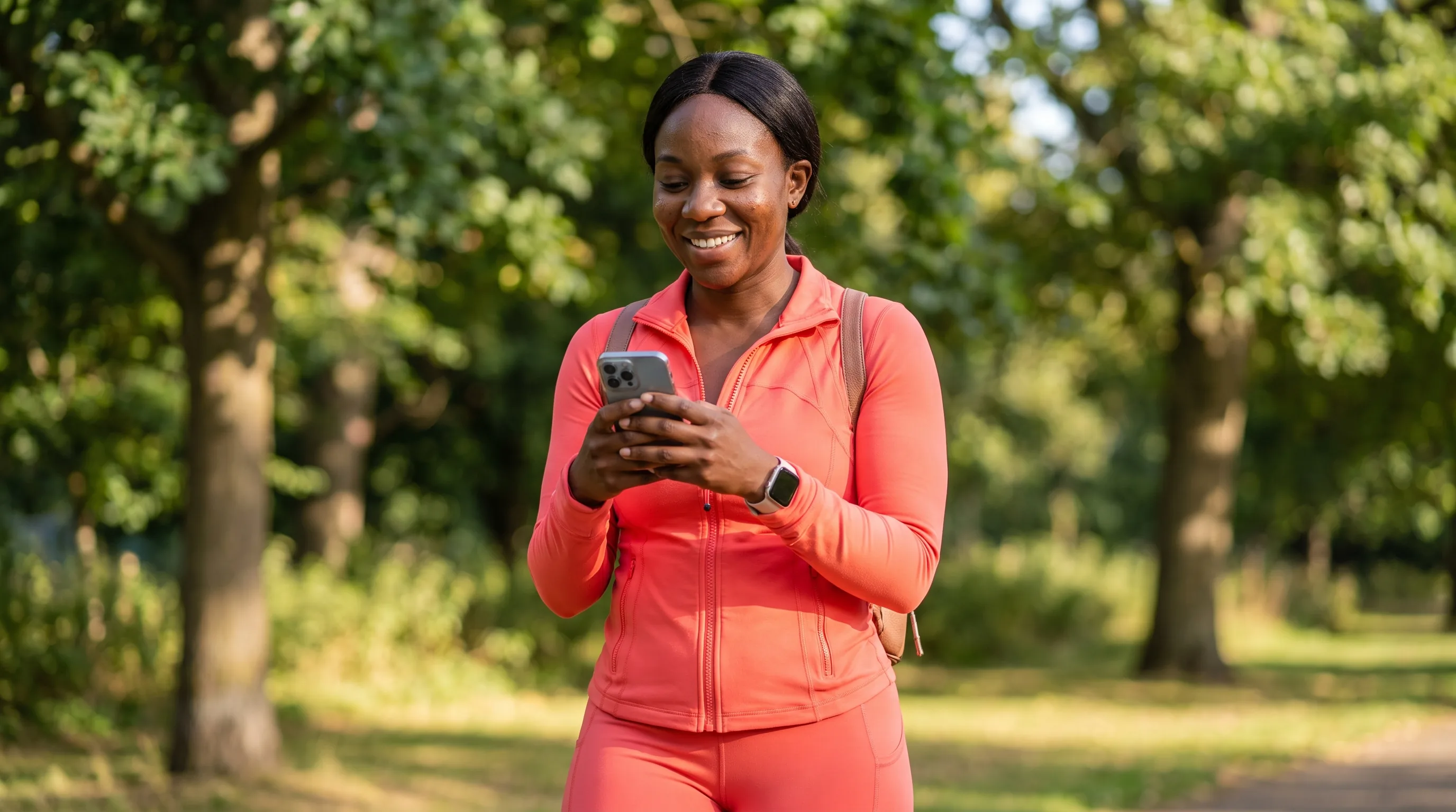 A cheerful, healthy woman in bright workout clothes smiling on a sunny morning walk, phone in hand, looking ready to switch providers