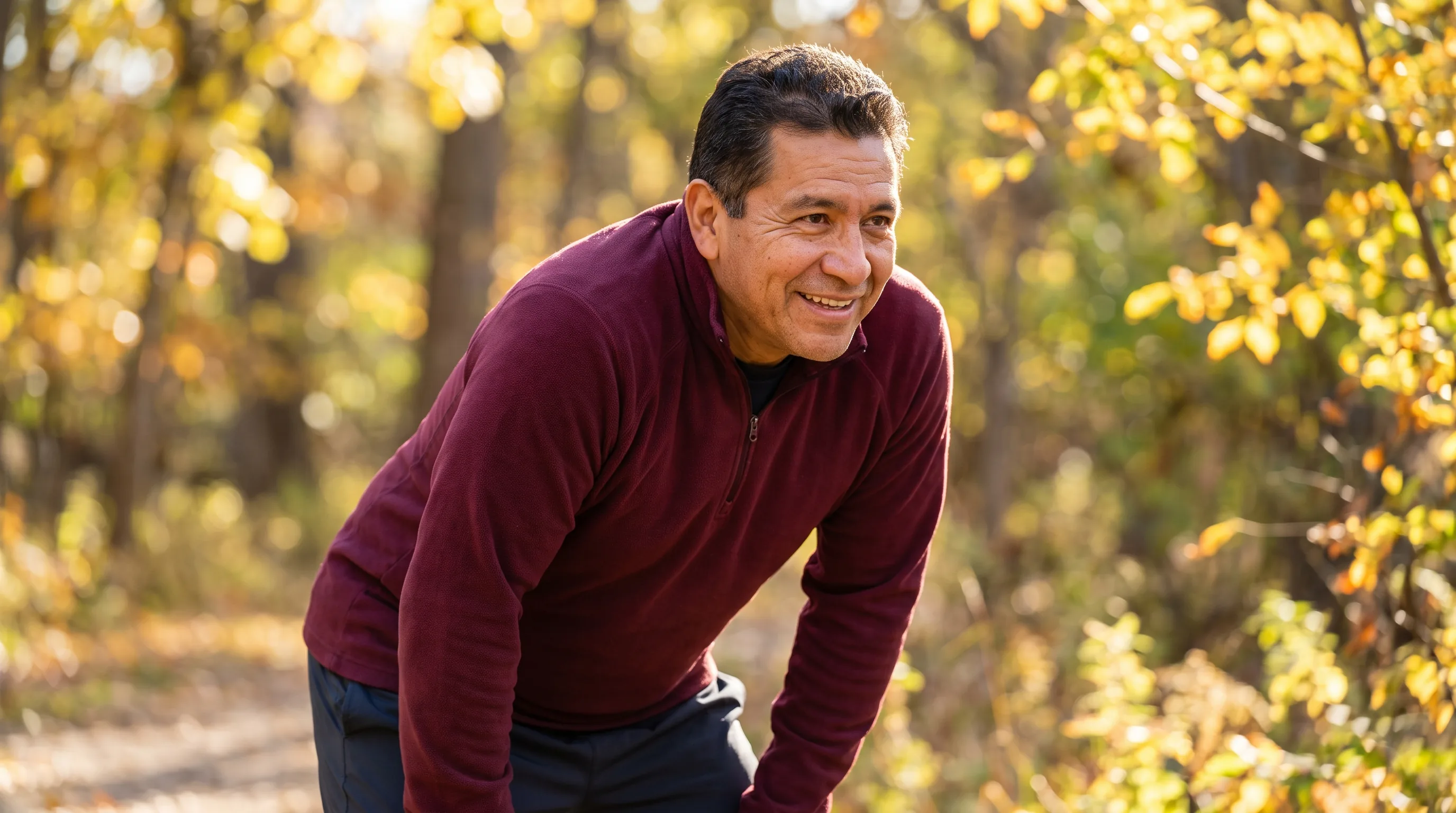 A vibrant active adult in their fifties smiling outdoors in warm morning light, healthy and energetic